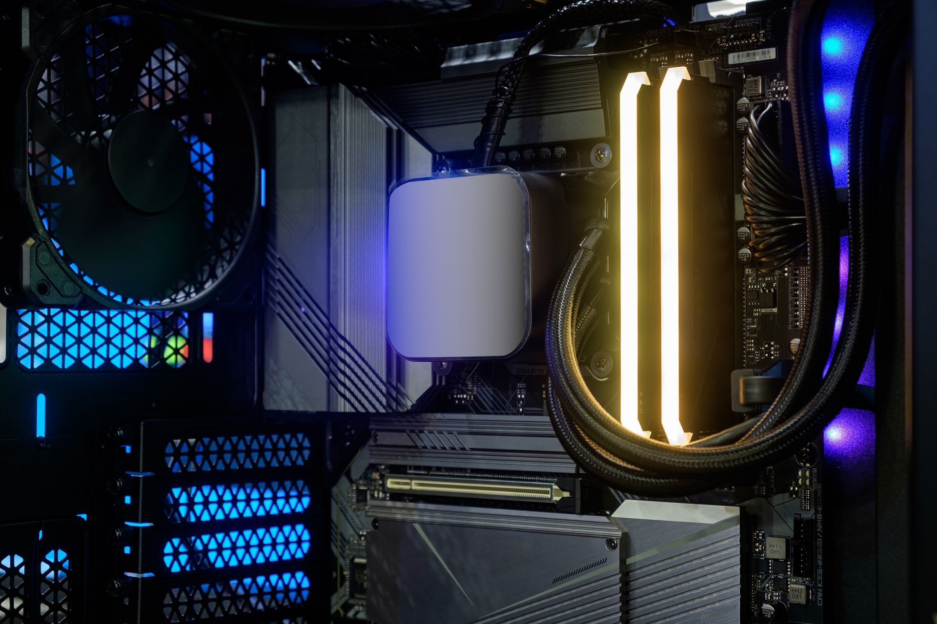 Inside a PC case with illuminated components: CPU cooler, RAM sticks, and fans.