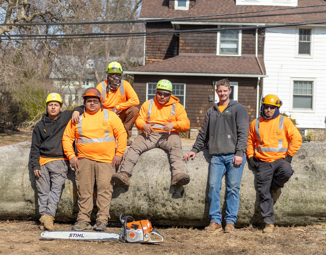 A group of men are posing for a picture in front of a house.