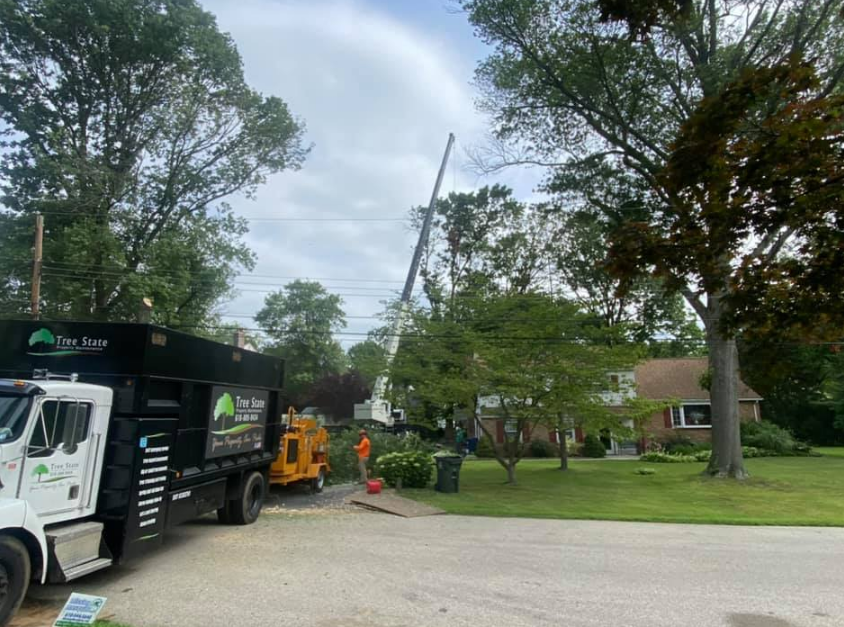 A truck is parked in front of a house with a crane in the background.