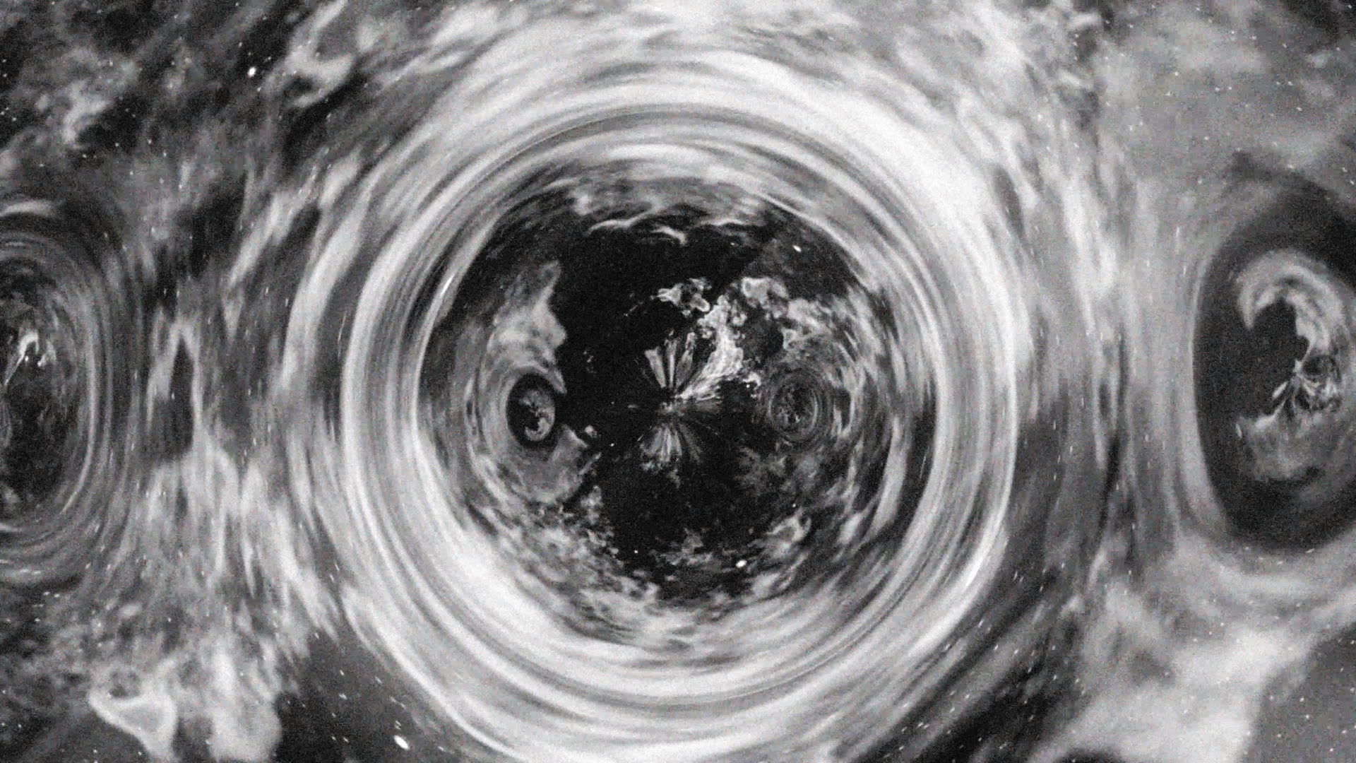A black and white photo of a black hole in space.
