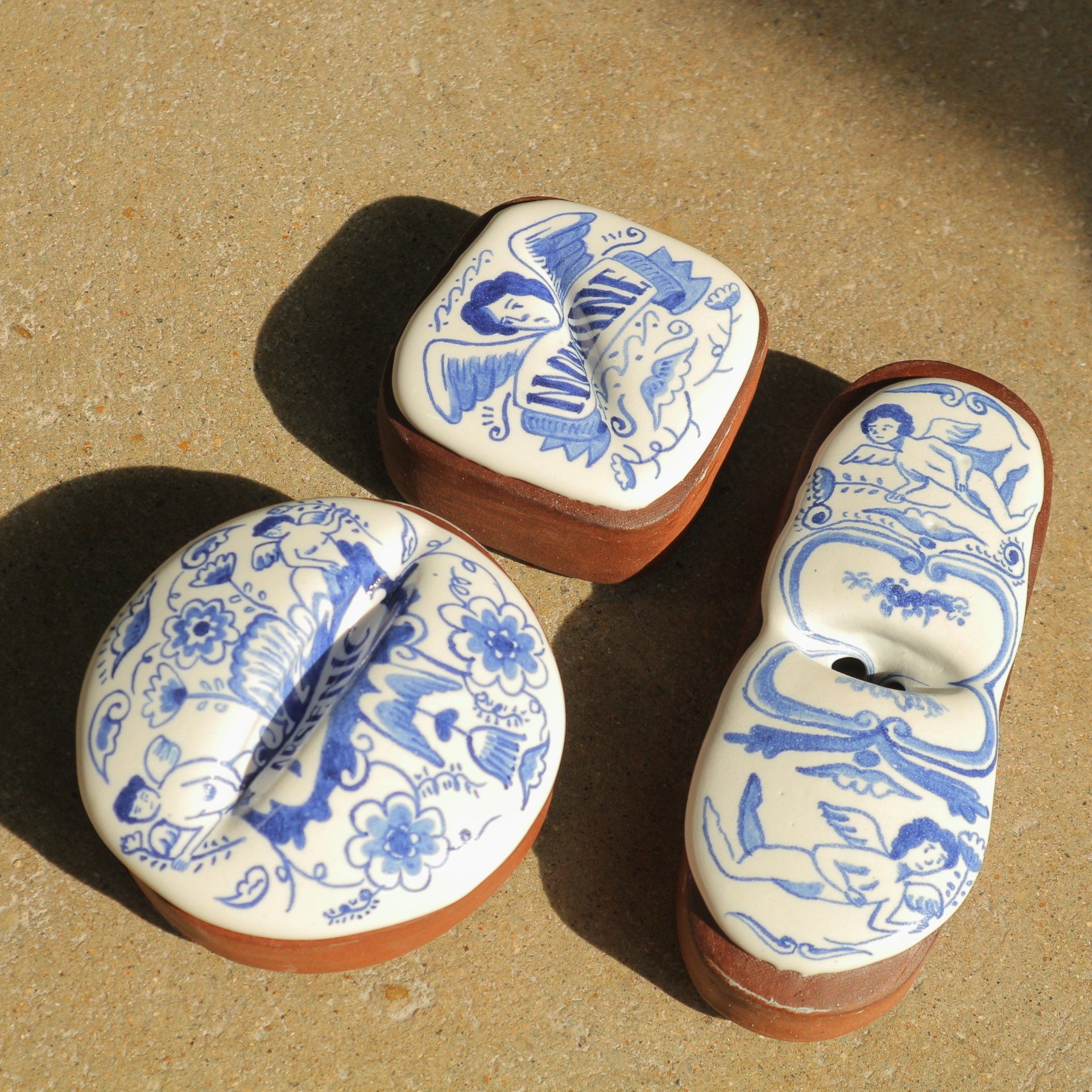 Three ceramic containers with blue and white designs on them