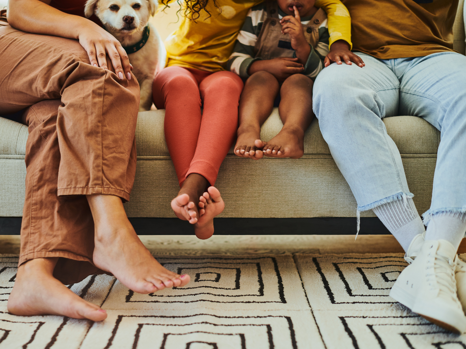 A family is sitting on a couch with a dog.
