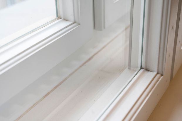 Telaio della finestra bianco con modanature intricate e vetri.