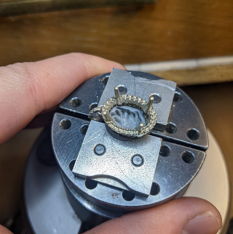 A person is holding a piece of metal with a ring in it