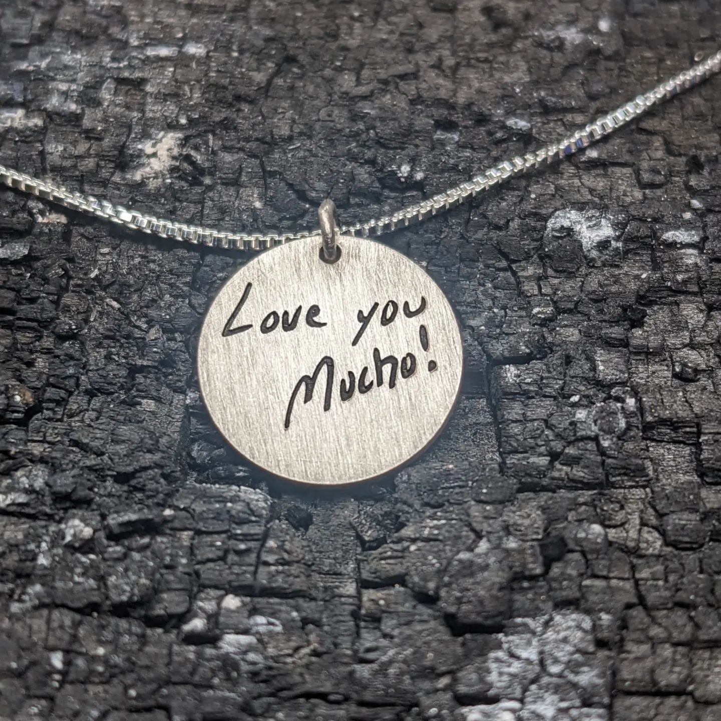 A necklace that says love you much on it