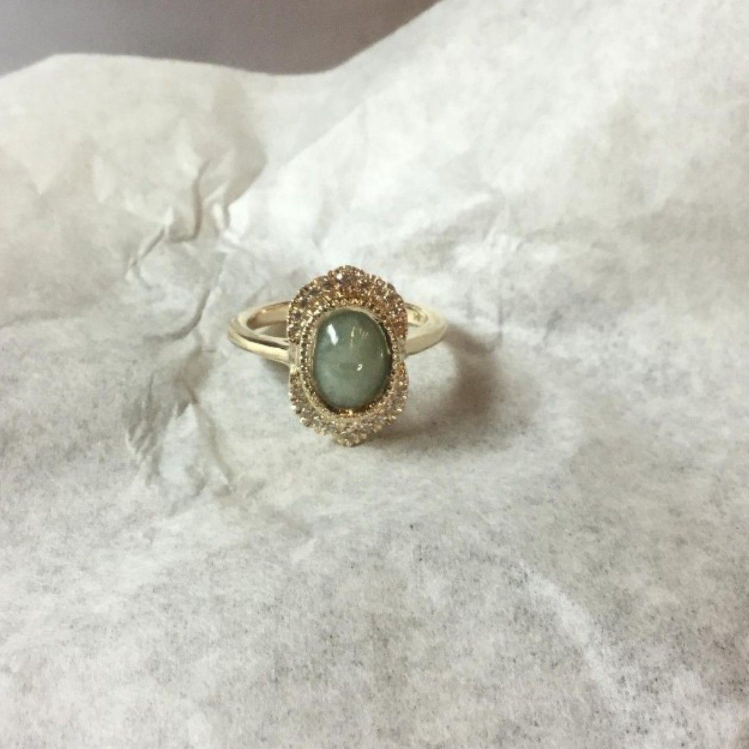 A gold ring with a green stone in the center