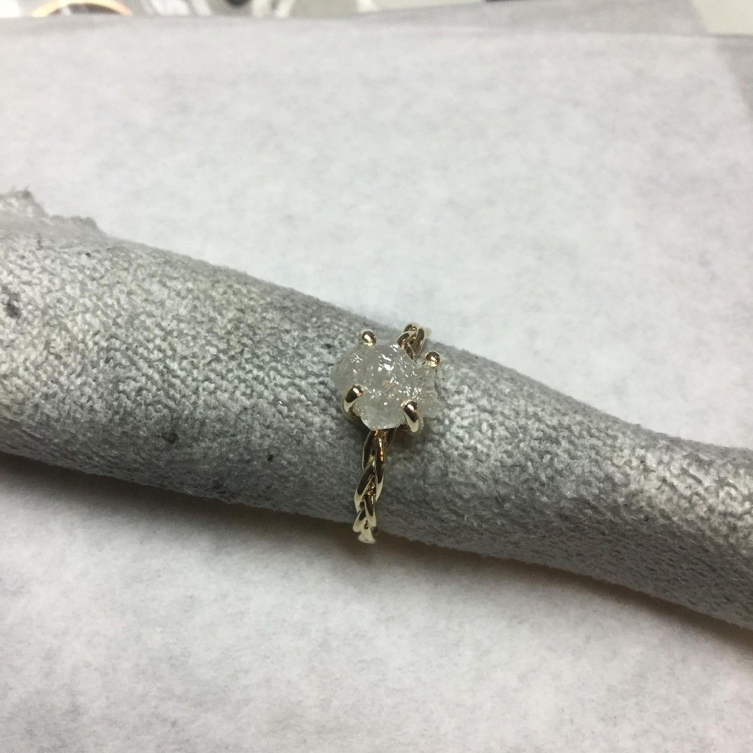 A ring with a diamond in the center is sitting on a napkin holder.