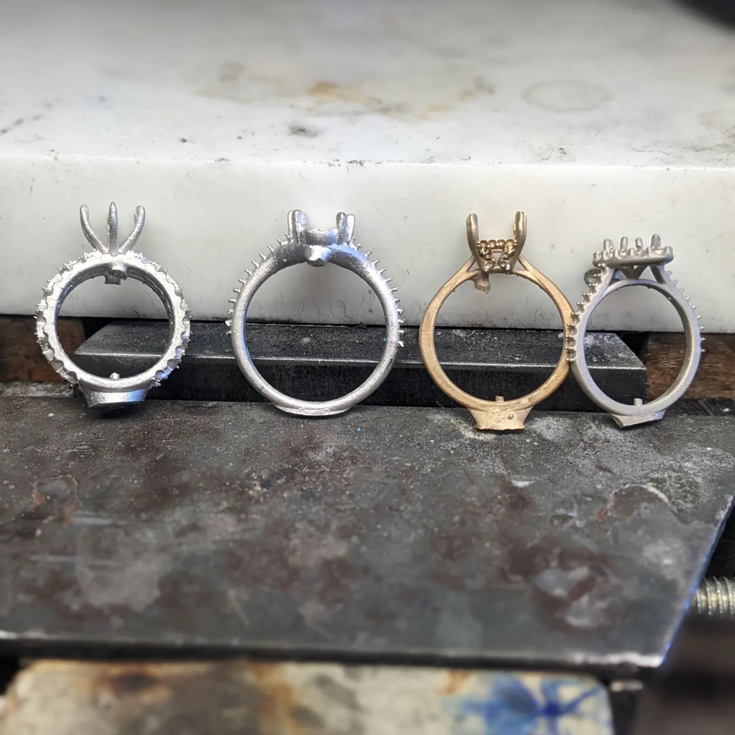 A row of rings are sitting on a metal surface