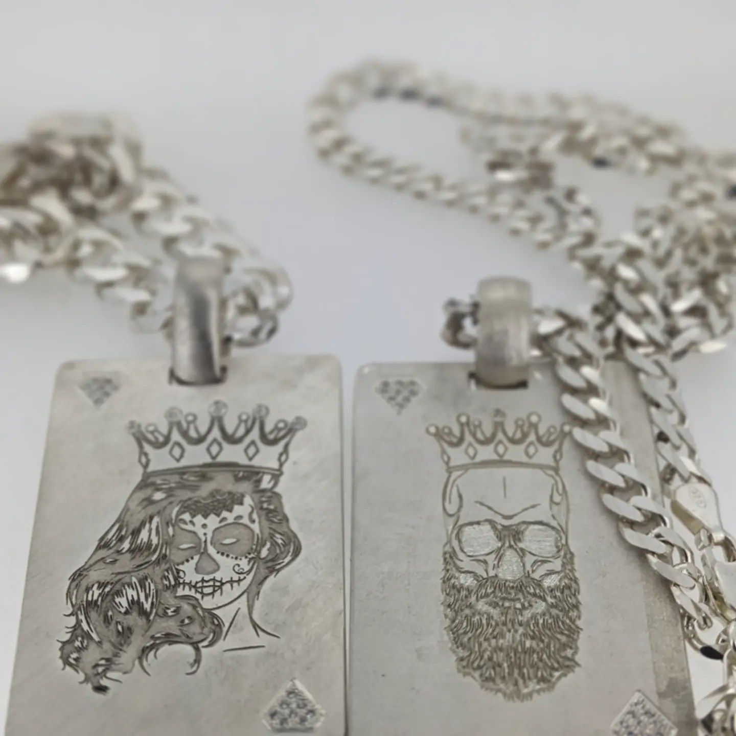 A king and queen playing card necklace with a chain