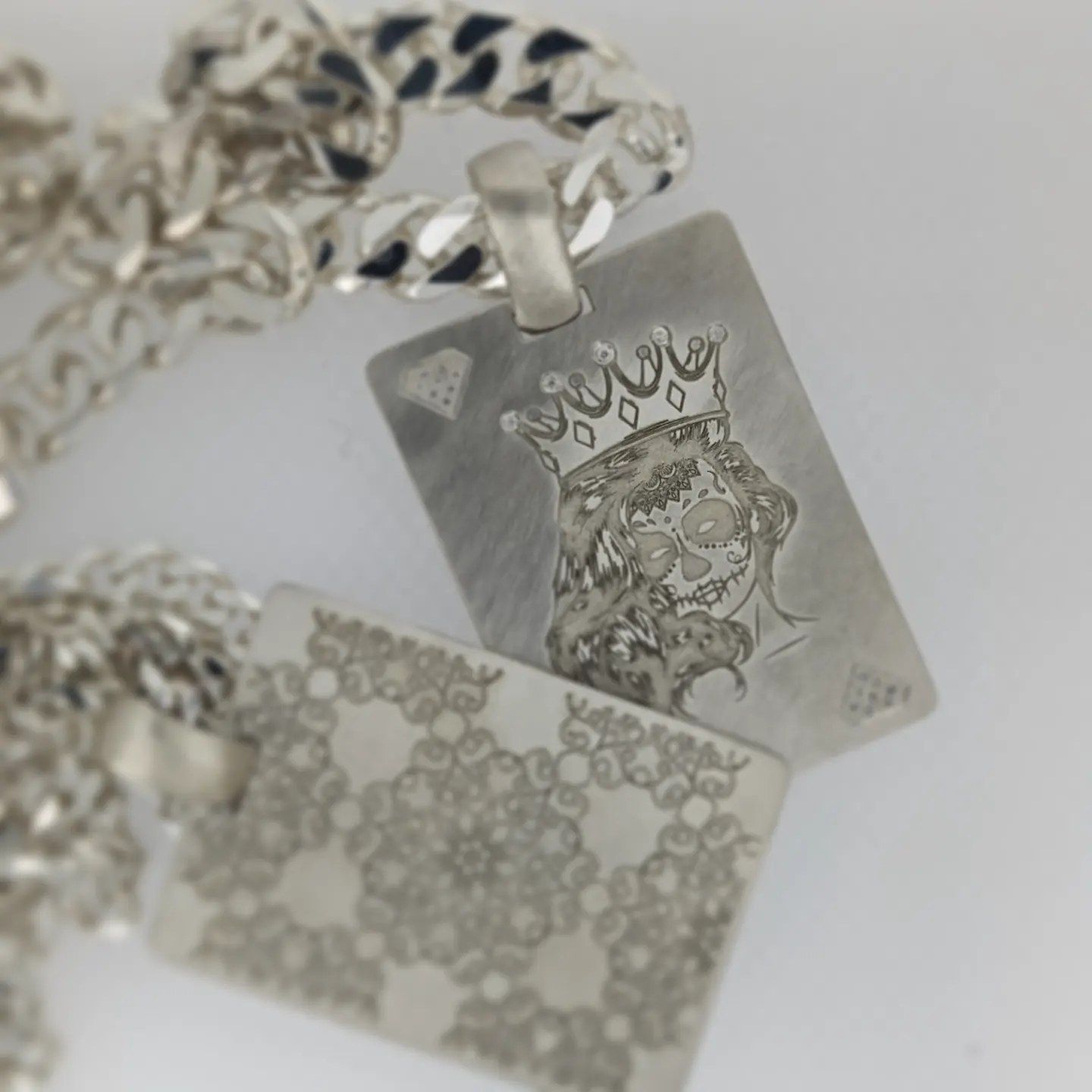 A silver pendant with a picture of a woman wearing a crown