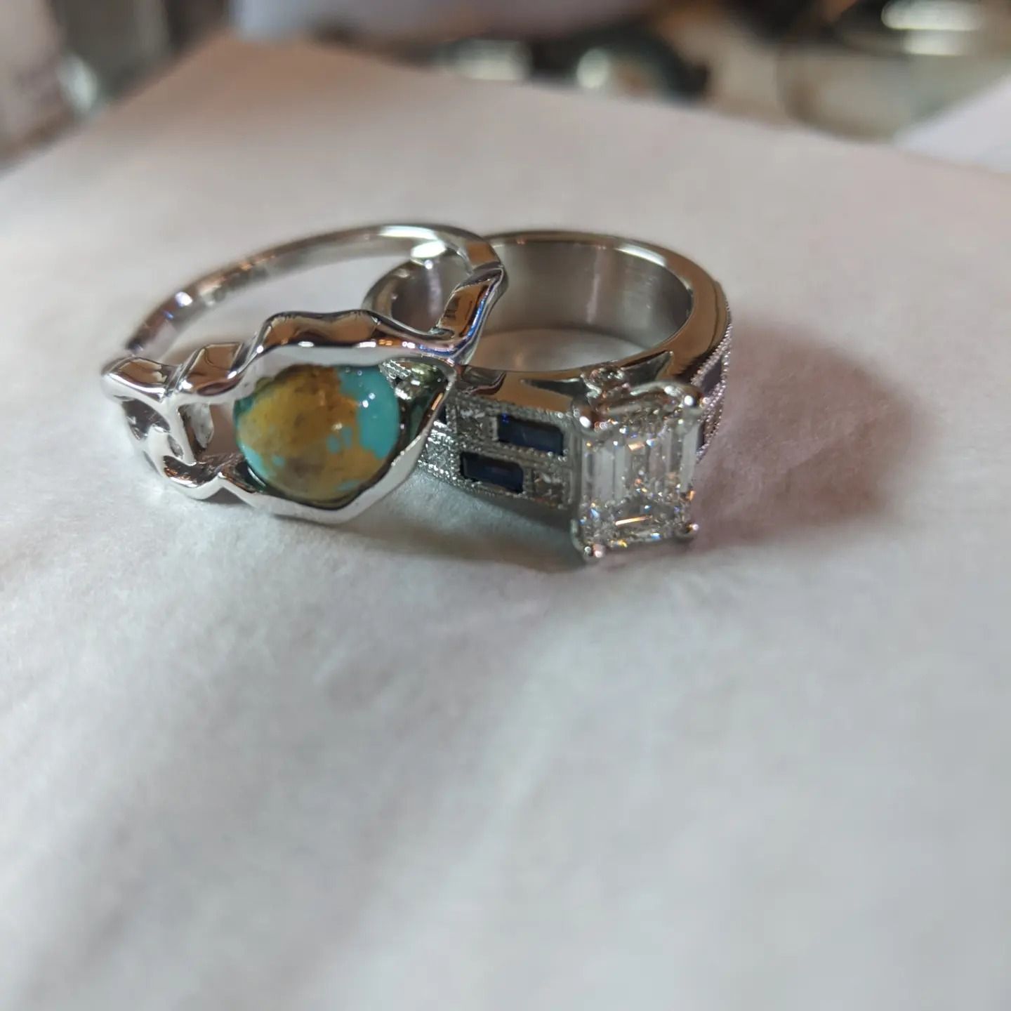 A couple of rings are sitting on a white cloth