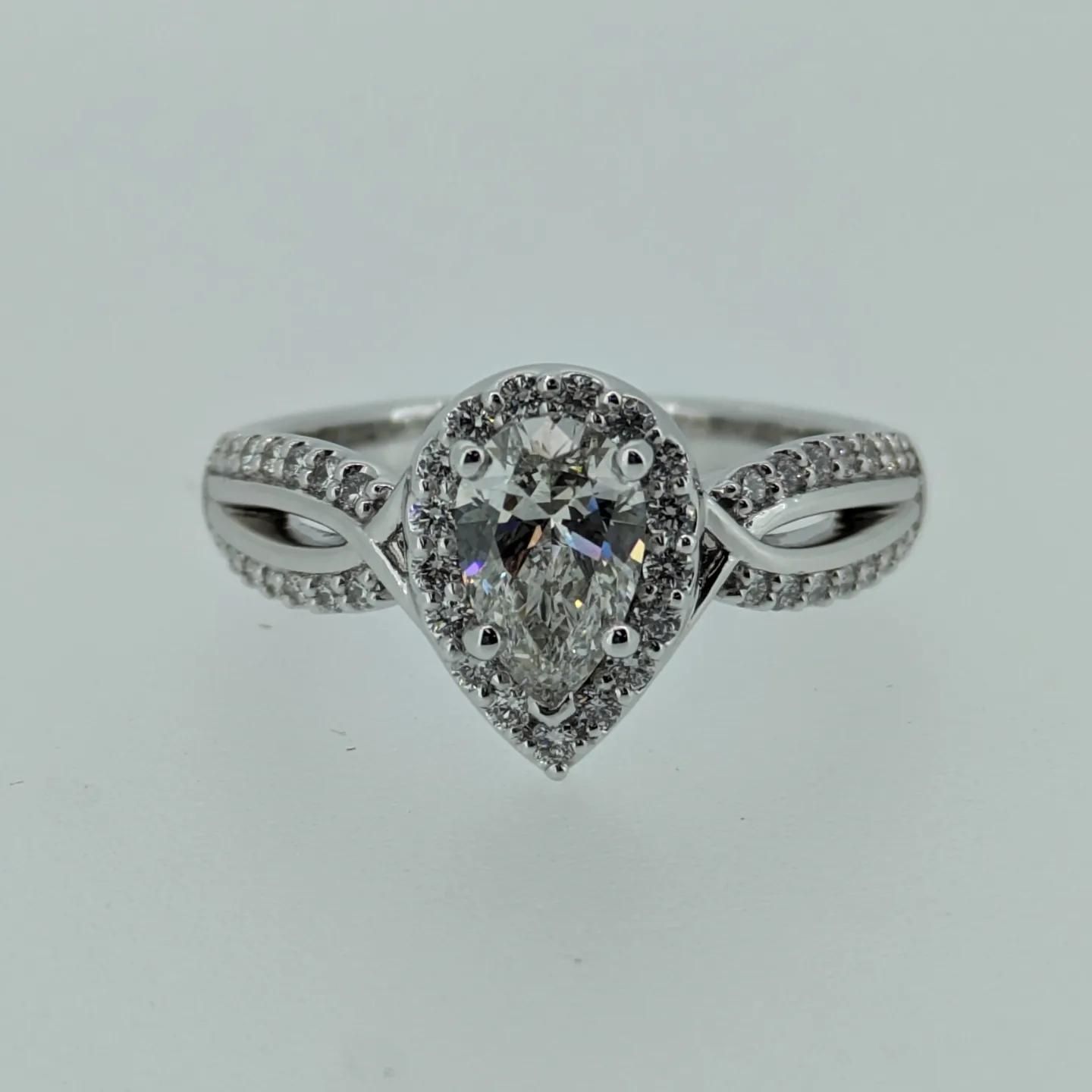 A white gold ring with a pear shaped diamond in the center