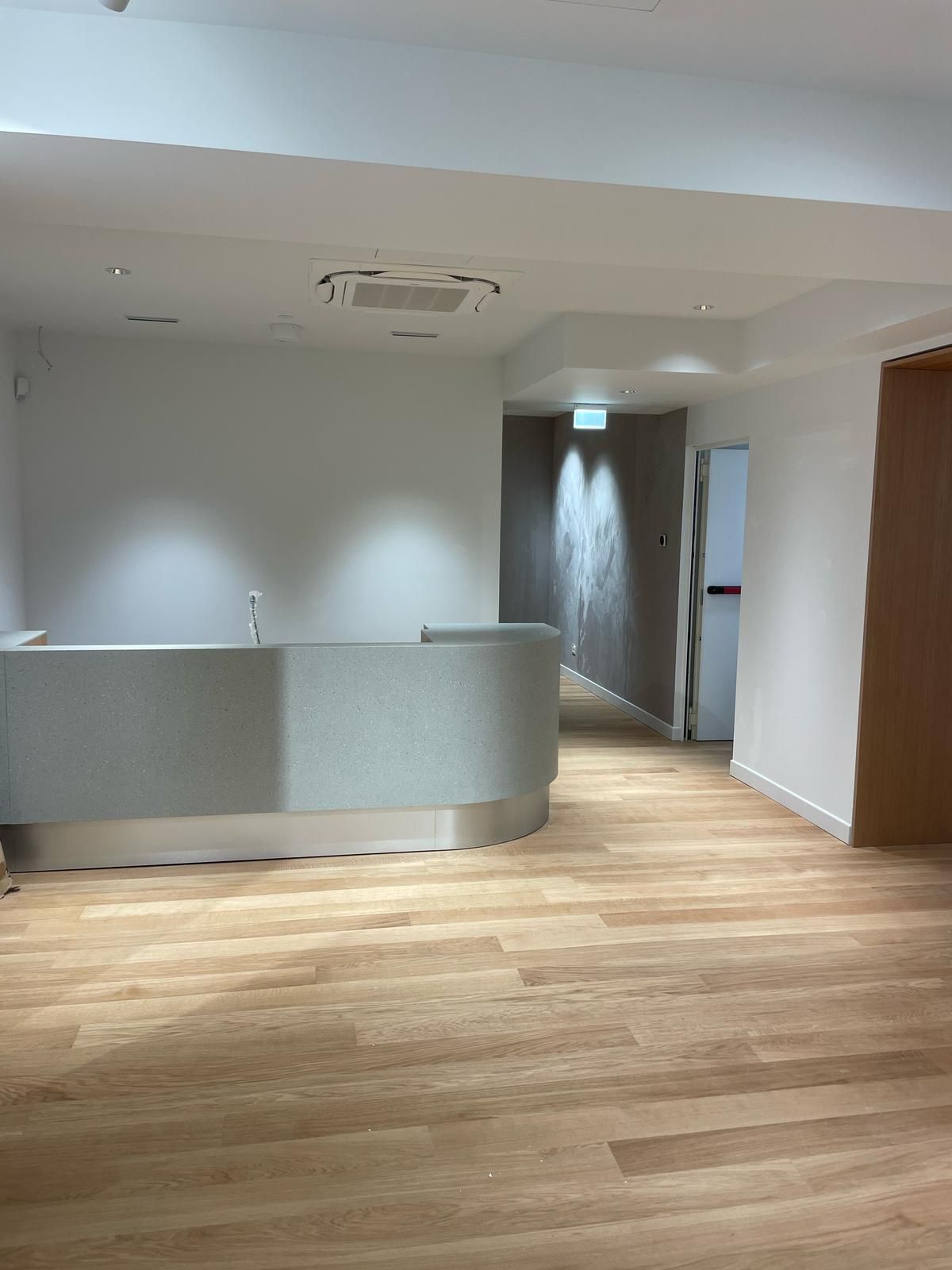 Una grande stanza vuota con un pavimento in legno e un bancone.