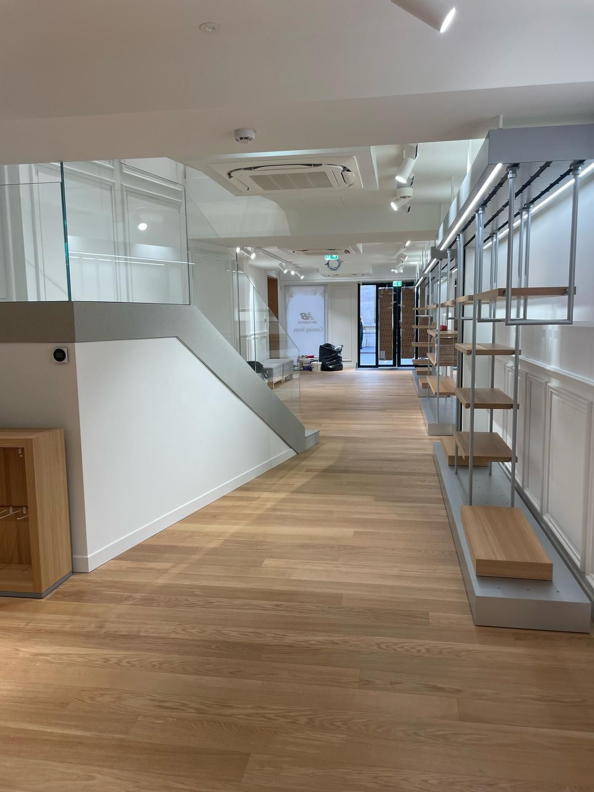 Una grande stanza vuota con pavimenti e scaffali in legno.