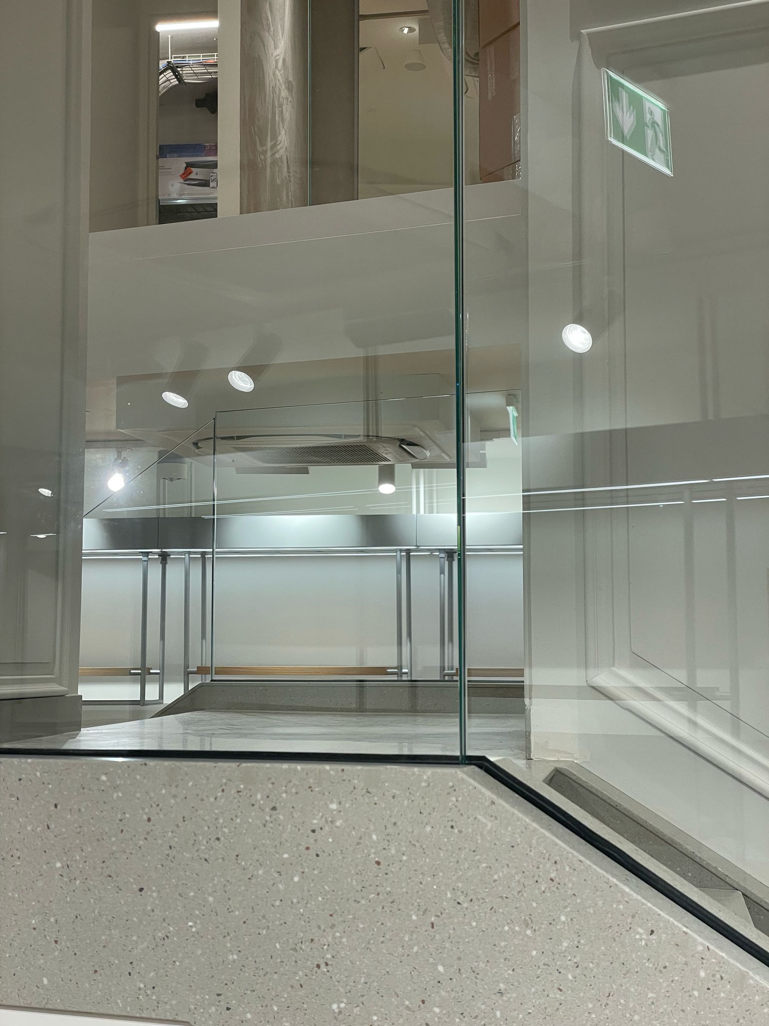 Una stanza con una porta a vetri e un cartello che dice uscita