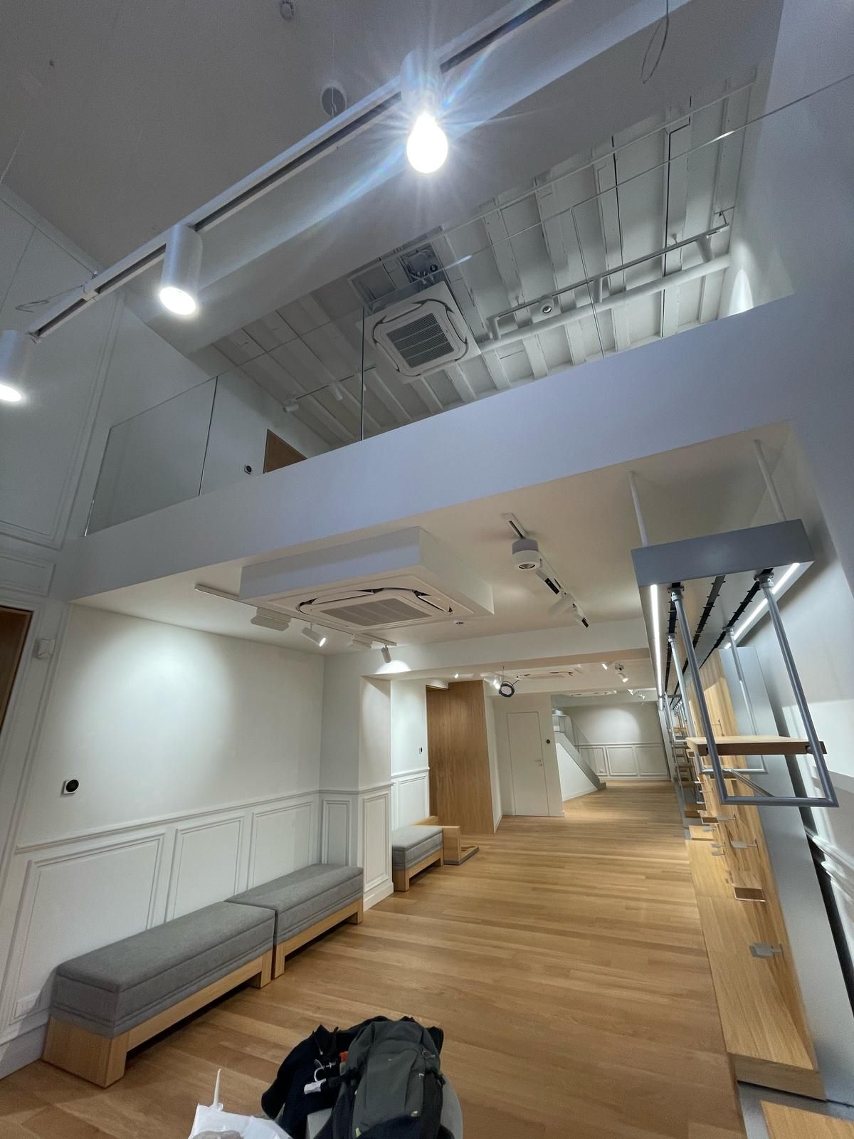 Una grande stanza vuota con pavimento in legno e soppalco.