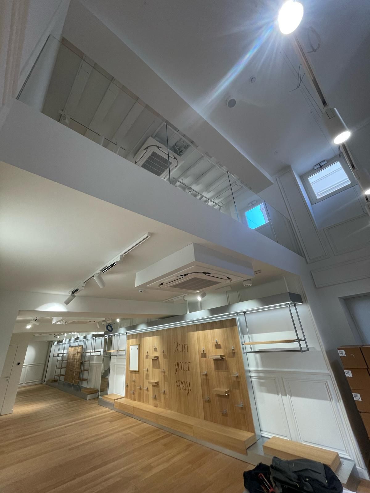 Una grande stanza con pavimento in legno e soffitto bianco.