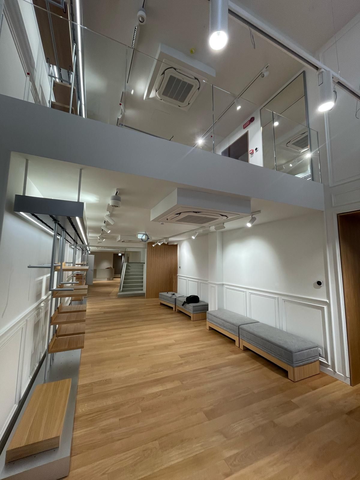 Una grande stanza vuota con pavimenti e scale in legno.