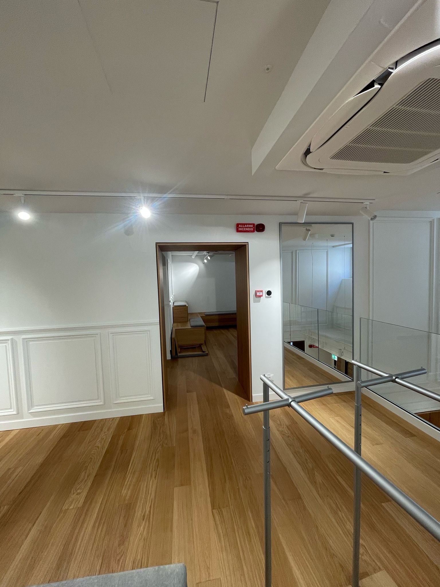 Una stanza con pavimento in legno e parete bianca.