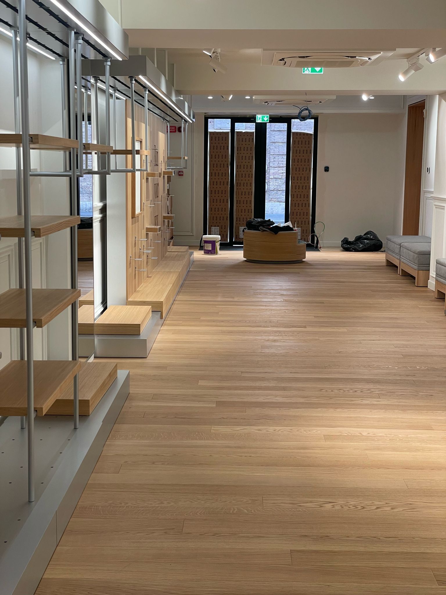 Una grande stanza vuota con pavimenti e scaffali in legno.