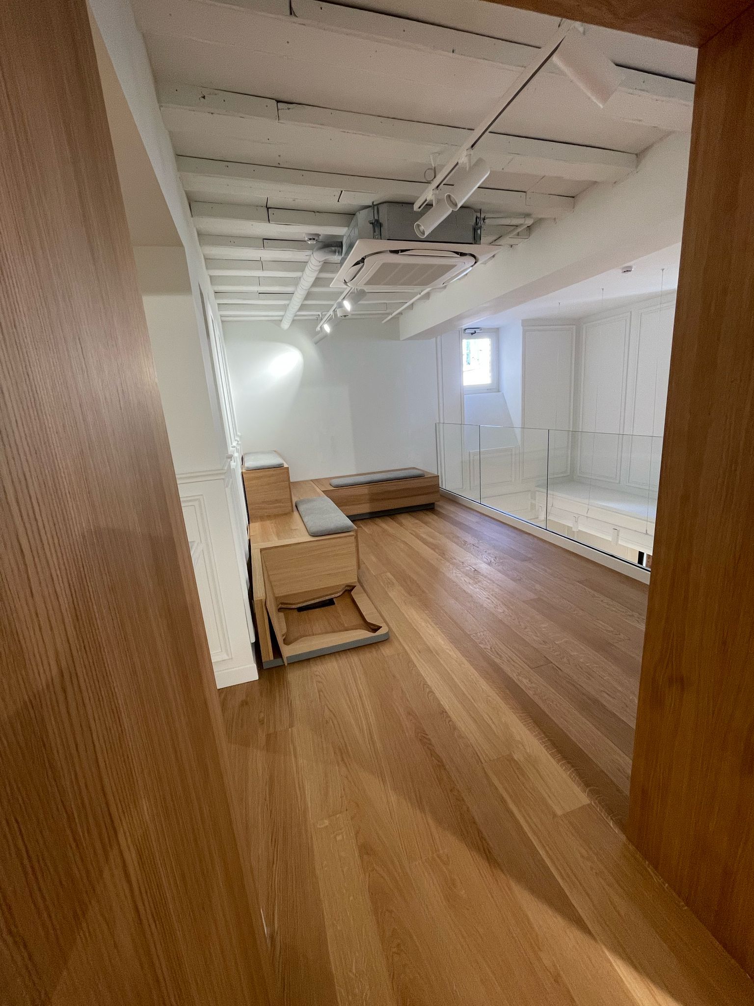 Una grande stanza con pavimenti in legno e pareti bianche.