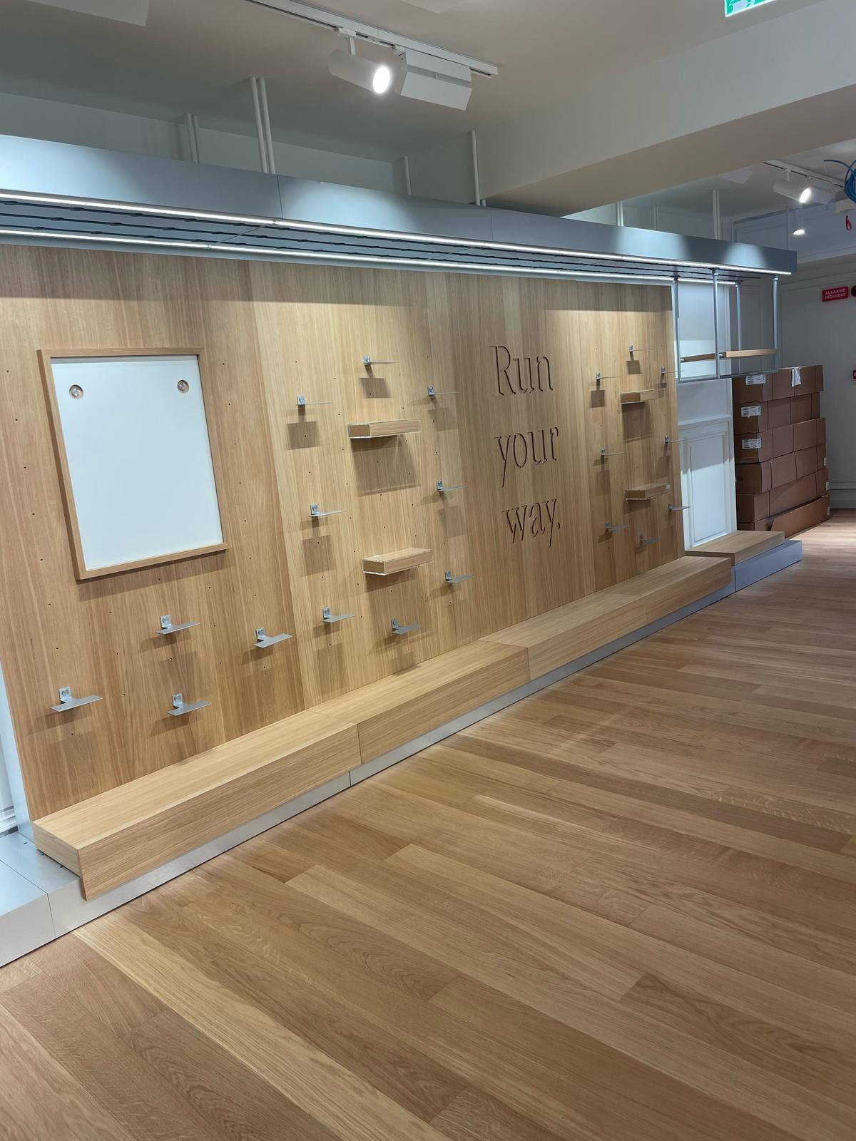 Una parete di legno con una lavagna bianca in una stanza con un pavimento in legno.