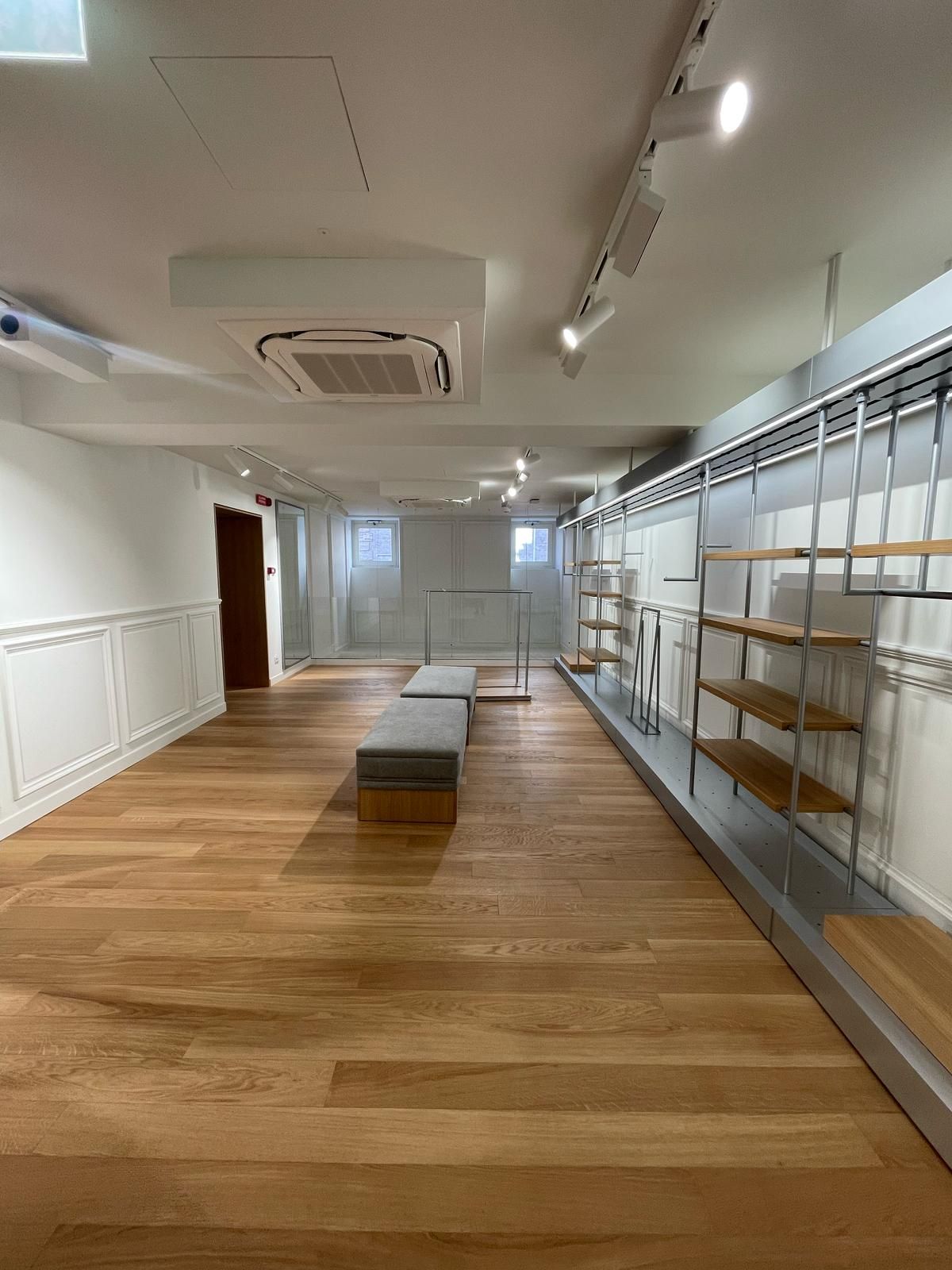 Una grande stanza vuota con pavimenti e scaffali in legno.