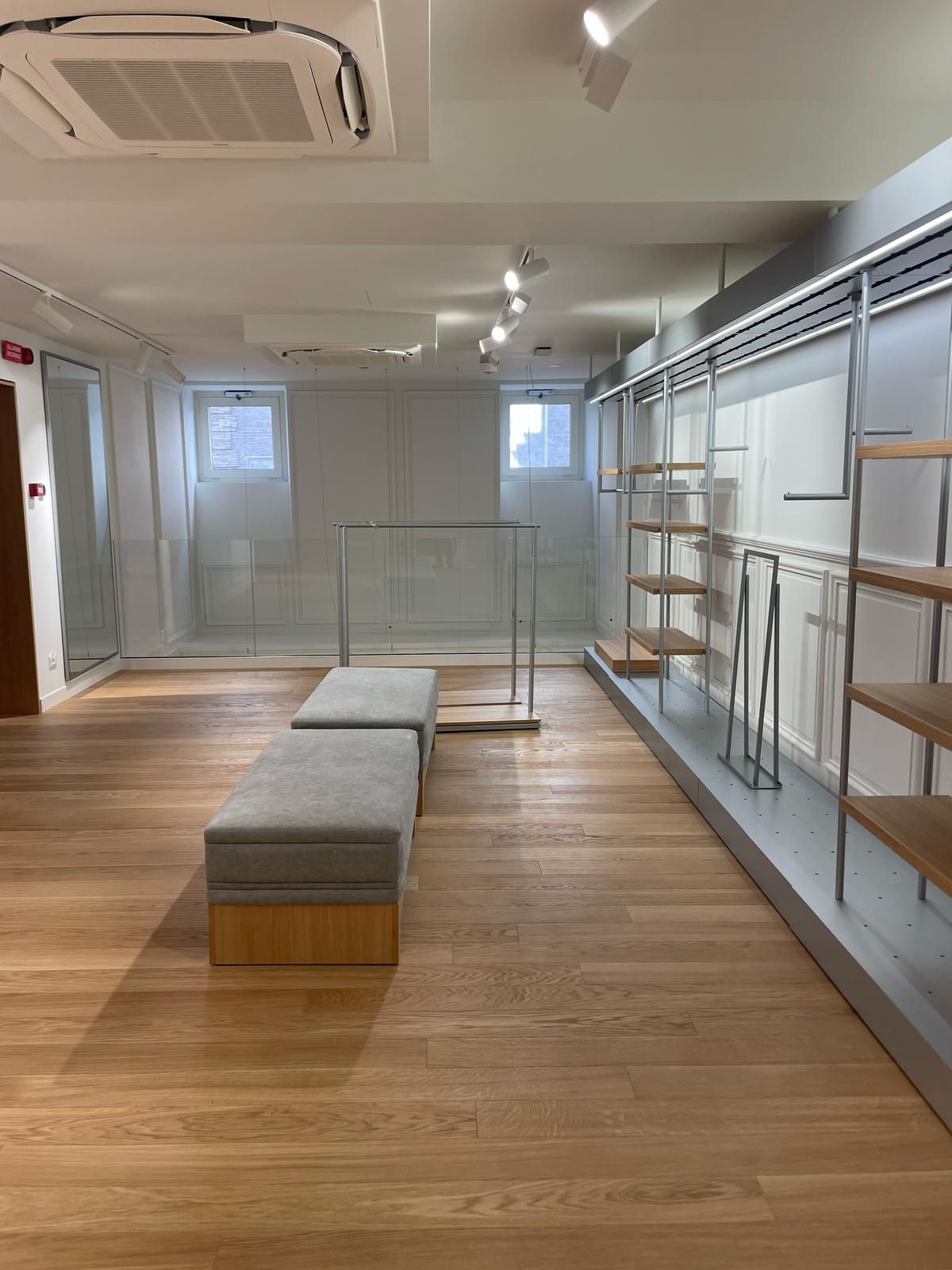 Una grande stanza vuota con pavimenti e scaffali in legno.