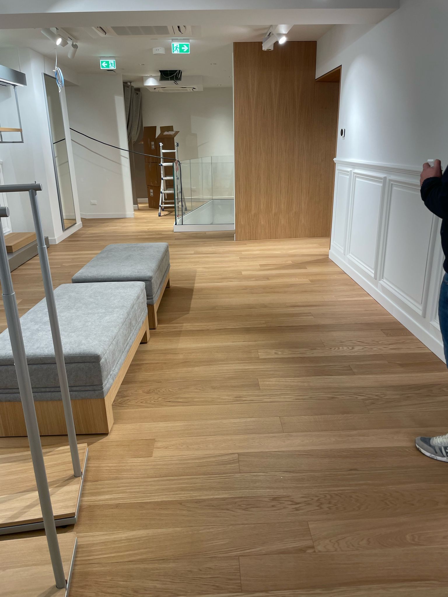 Una persona sta scattando una foto di una stanza con pavimenti in legno.