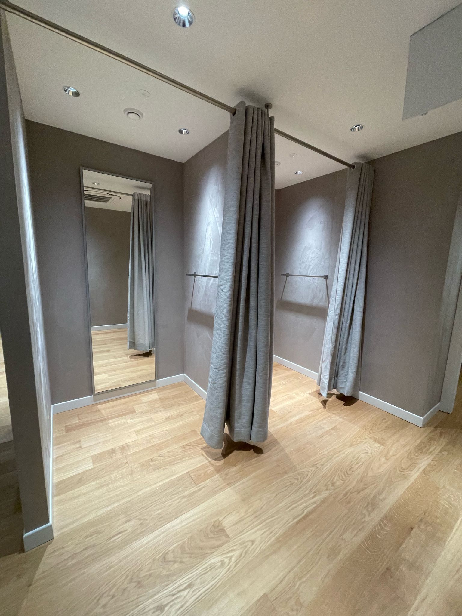 Uno spogliatoio con un grande specchio e delle tende.