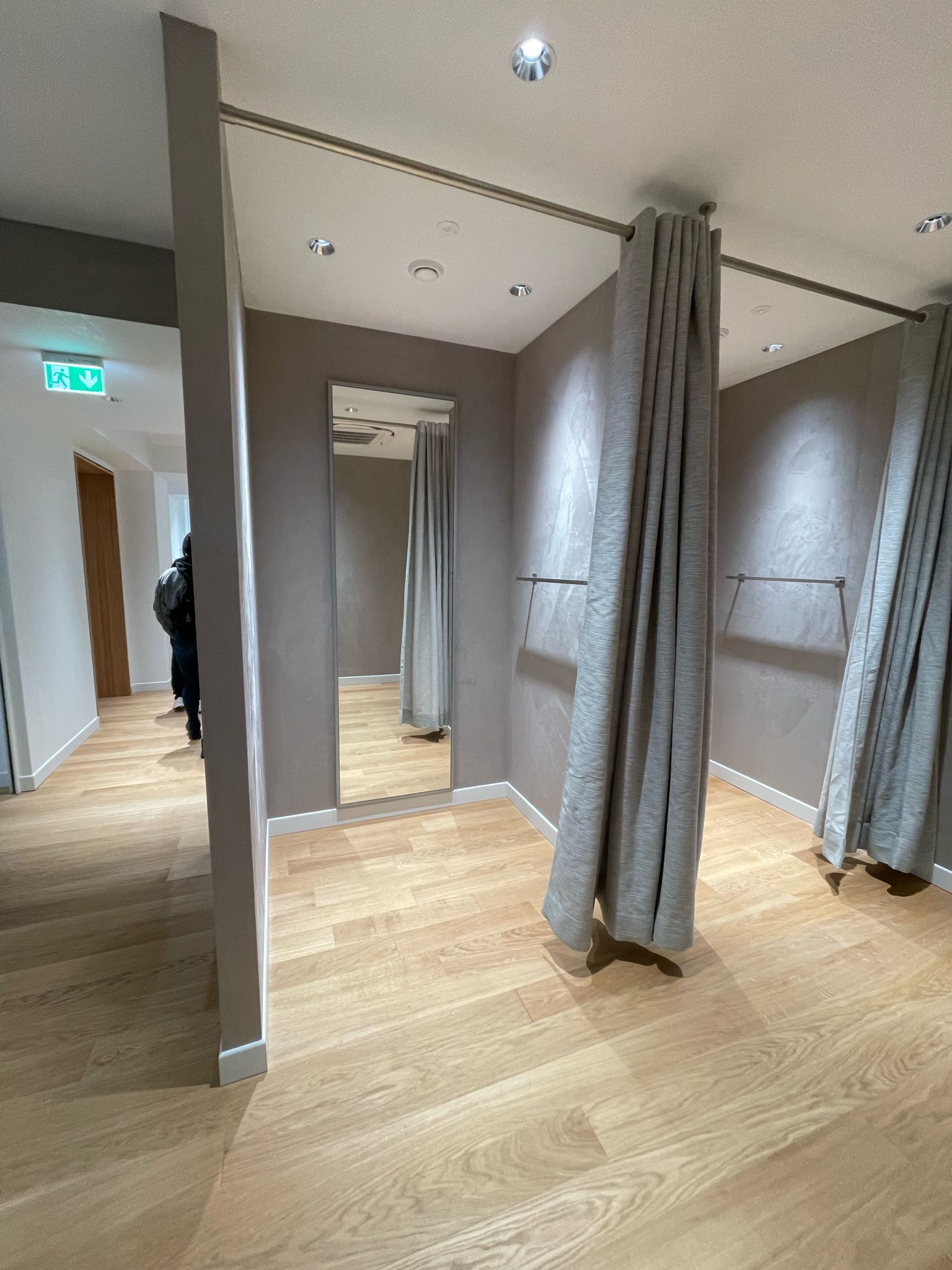 Uno spogliatoio con un grande specchio e delle tende.