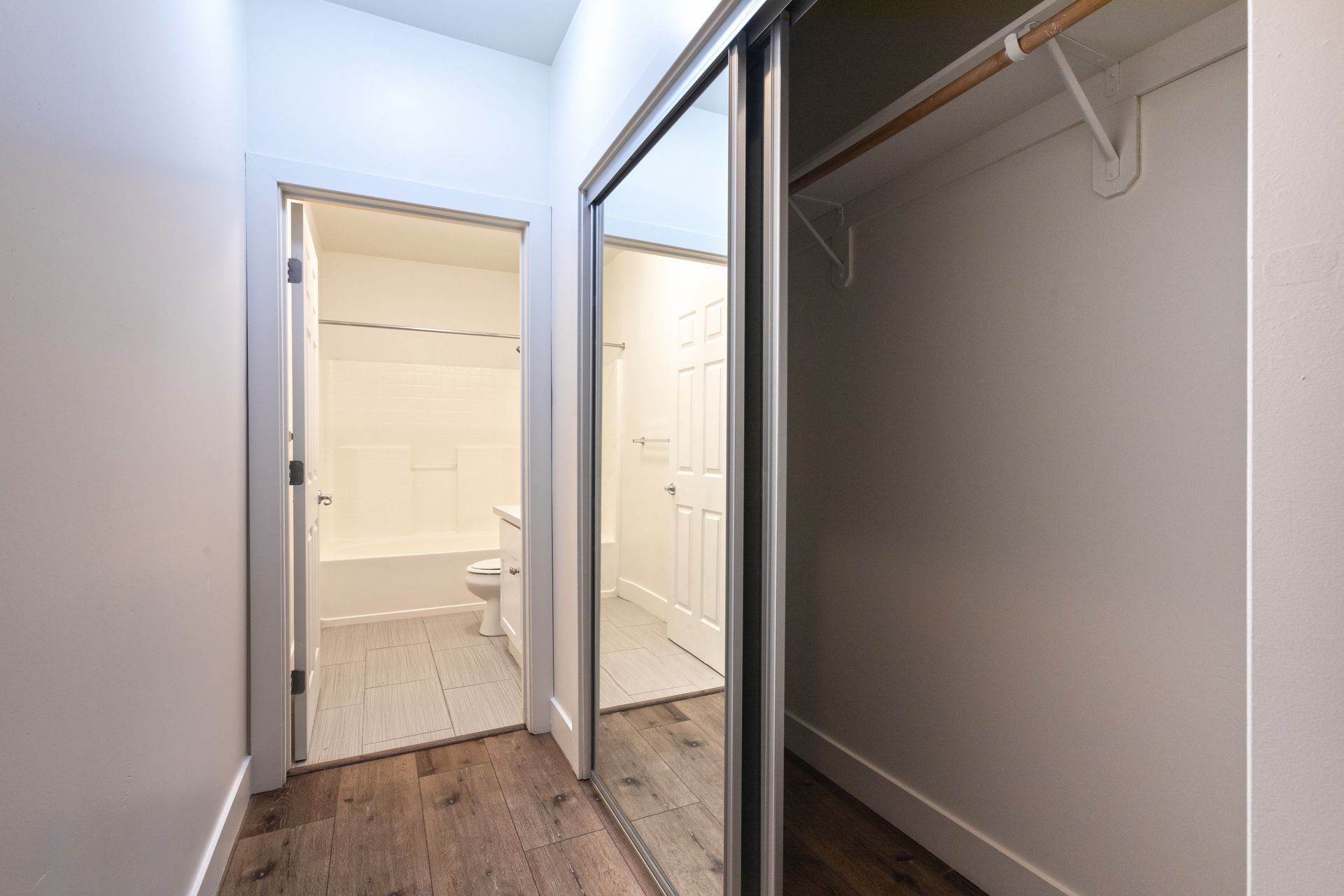 A walk in closet with sliding glass doors leading to a bathroom.