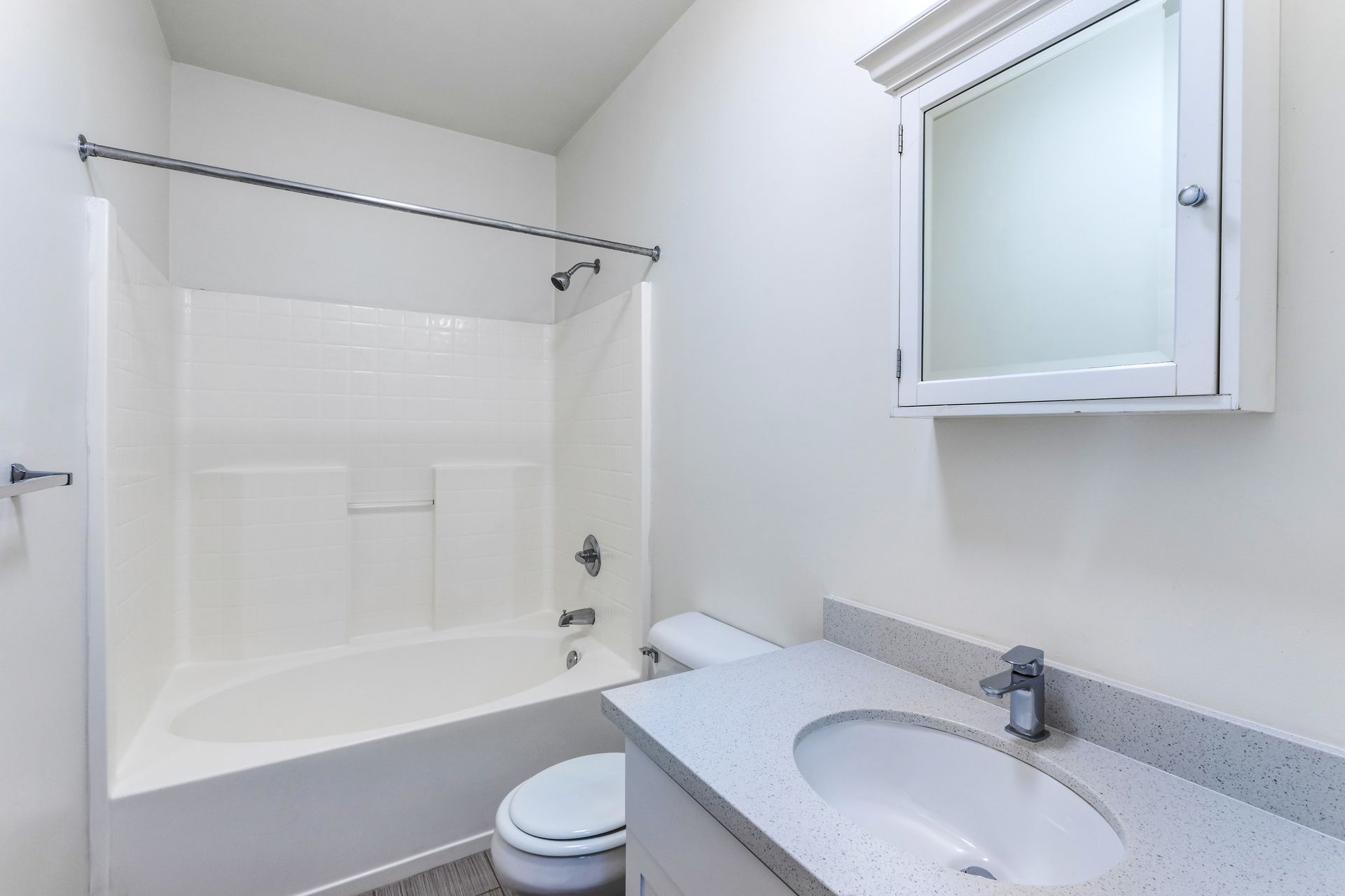 A bathroom with a sink , toilet , bathtub and mirror.