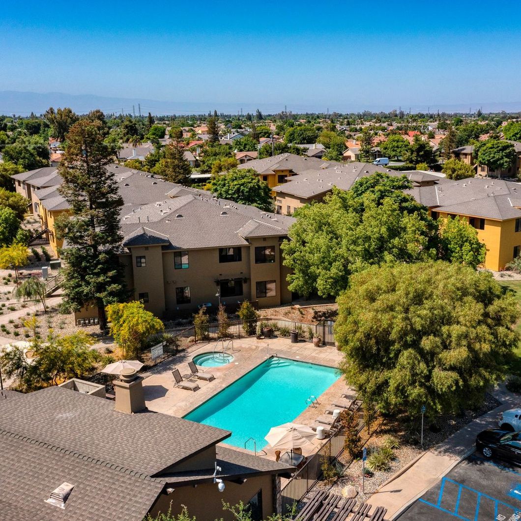 An aerial view of a residential area with a large swimming pool in the middle.