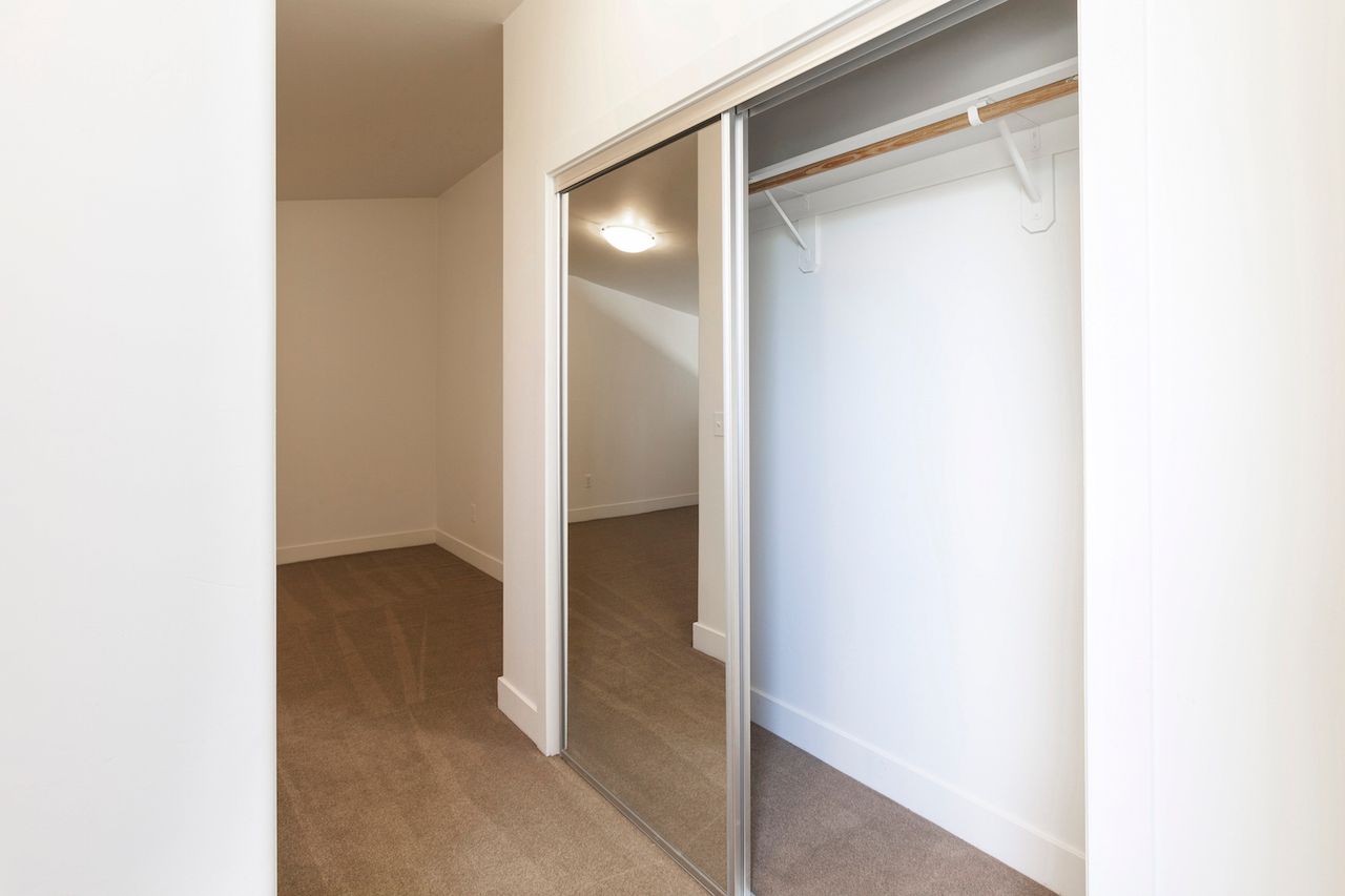 An empty walk in closet with sliding glass doors.