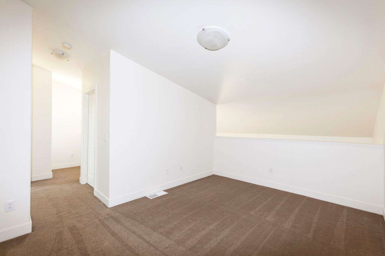 An empty room with a brown carpet and white walls