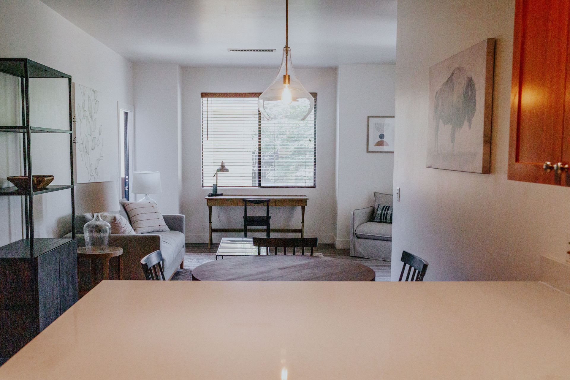 A living room with a couch , table , chairs and a desk.