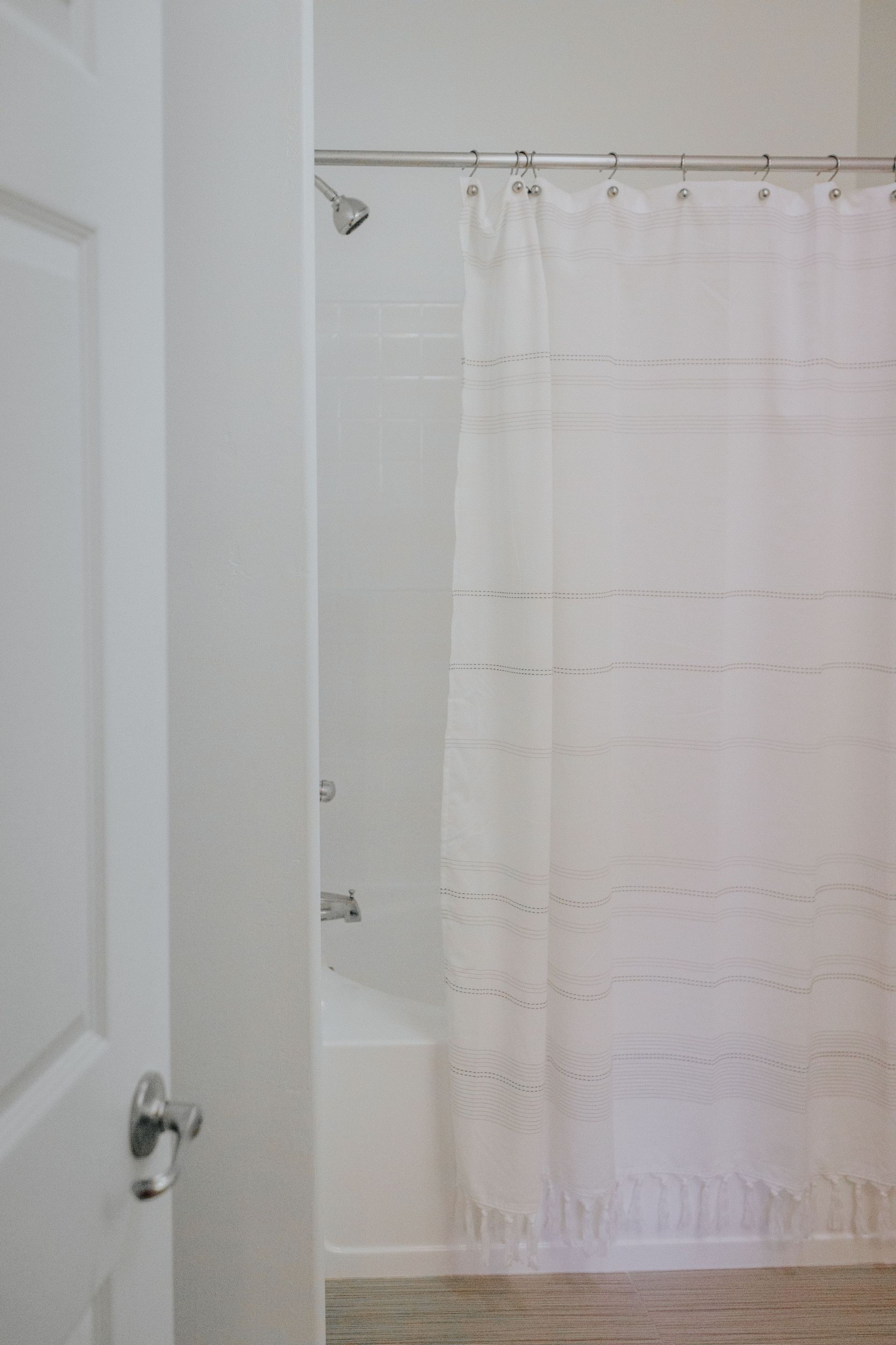 A bathroom with a shower curtain and a bathtub.