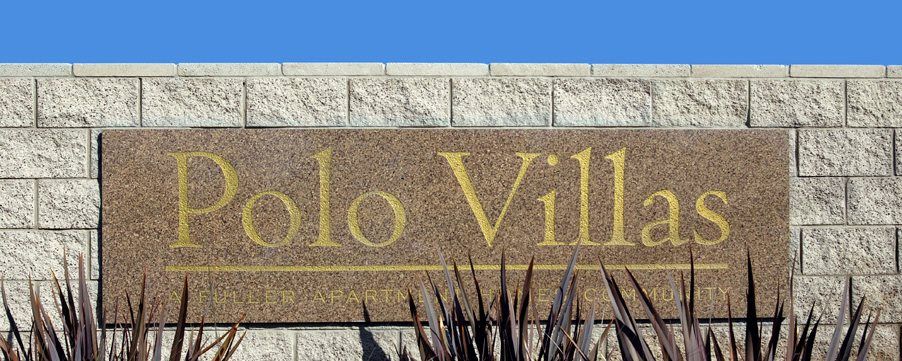 A sign on a brick wall that says polo villas