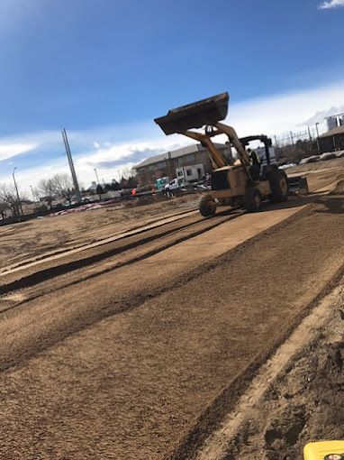 A bulldozer is driving down a dirt road.