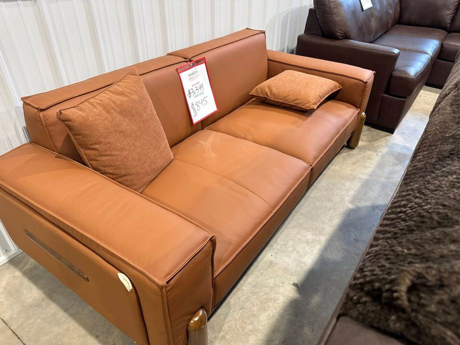Brown leather sofa with two matching pillows, showroom.