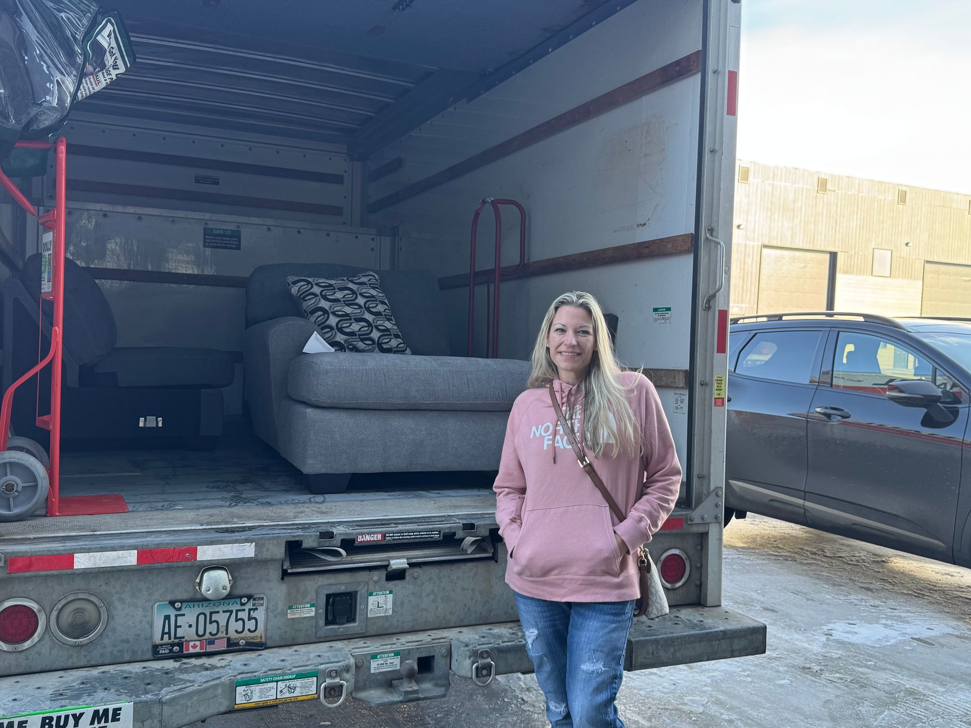 Furniture showroom: brown leather sectional sofa, reclining chairs, and round coffee table.