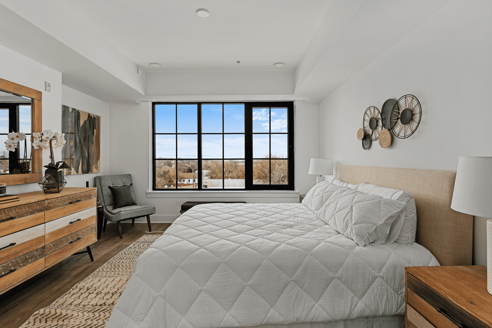 A bedroom with a large bed and a large window.