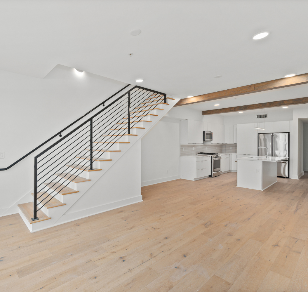 A living room with a staircase leading up to the second floor