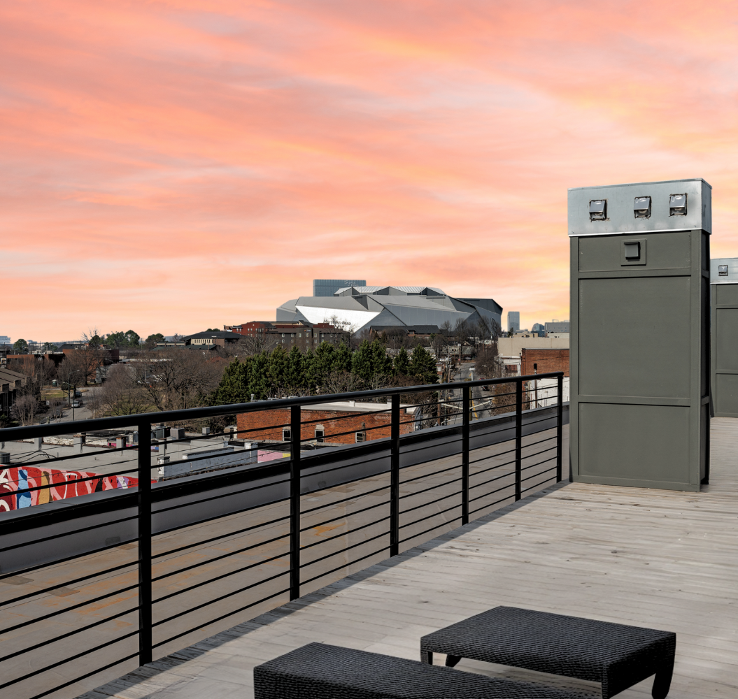 A balcony with a view of a city at sunset