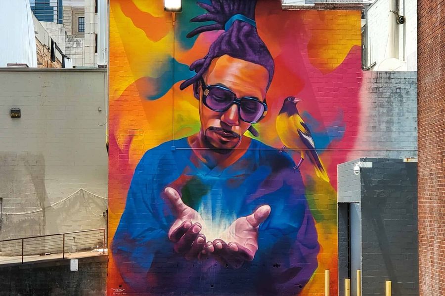 A colorful mural of a man holding something in his hands