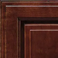 Close-up of a dark wood cabinet corner with a layered design, highlighting the paneling and rich brown tones.