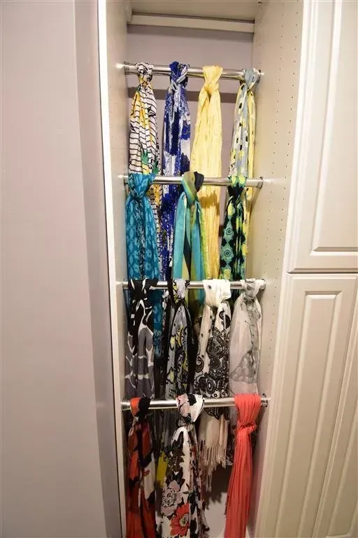 Closet organizer with scarves hanging from rods, various colors and patterns.
