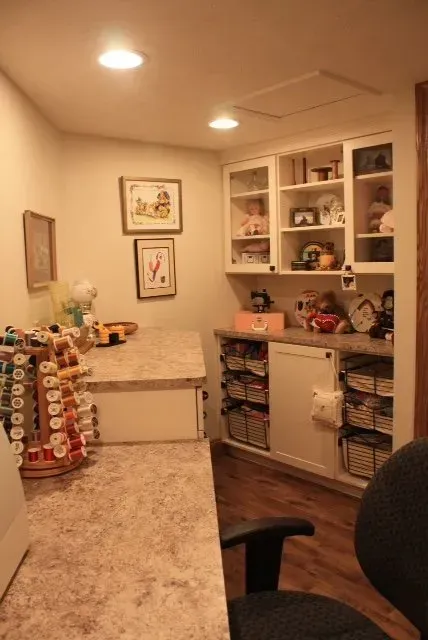 Craft room with a large work surface, built-in cabinets, and organized supplies.