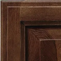 Close-up of dark wood cabinet door showing recessed panel and frame detailing.